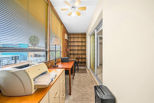 carpeted office with built in features and ceiling fan