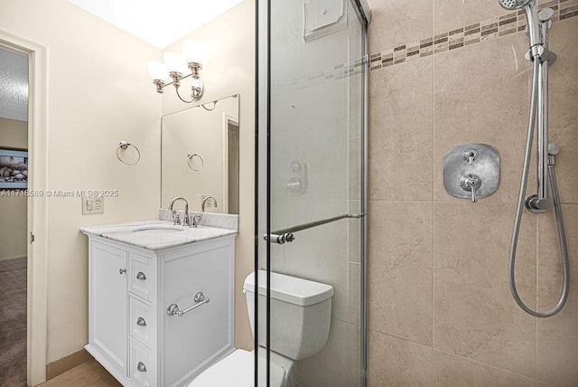 bathroom with a tile shower, vanity, and toilet