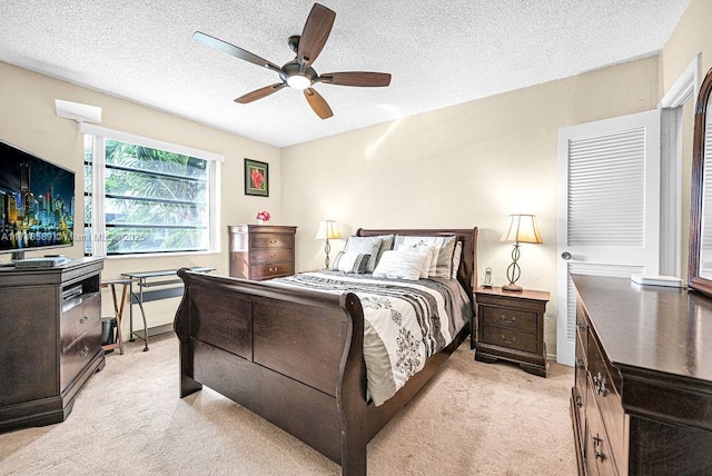 carpeted bedroom with ceiling fan and a textured ceiling