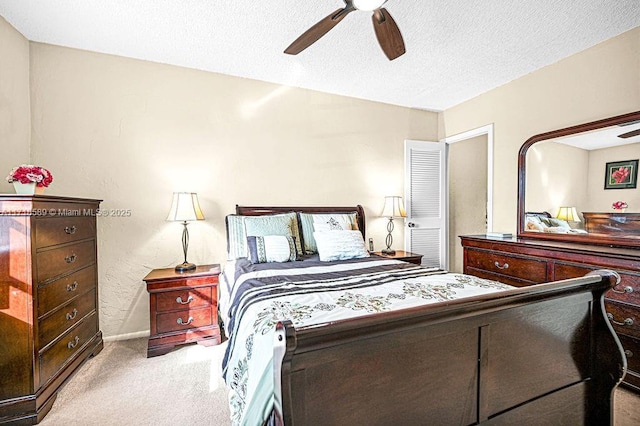 carpeted bedroom with ceiling fan and a textured ceiling