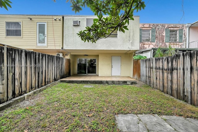 rear view of property with a patio and a lawn