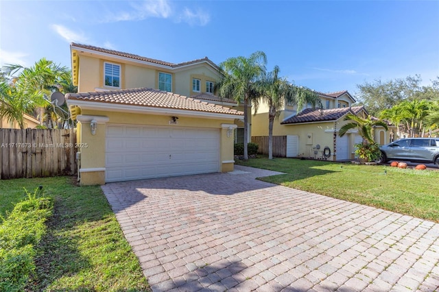 mediterranean / spanish-style home with a garage and a front lawn