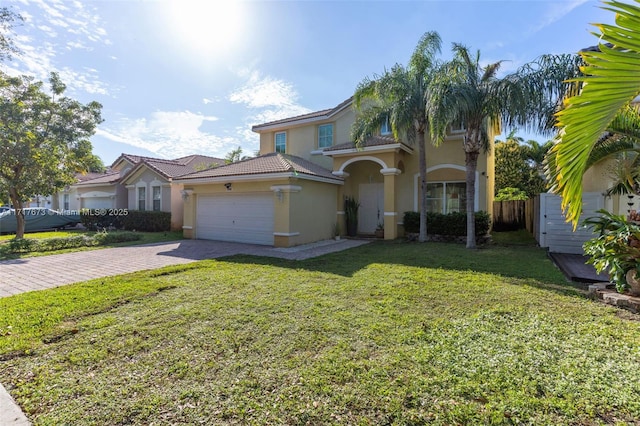 mediterranean / spanish home with a garage and a front lawn