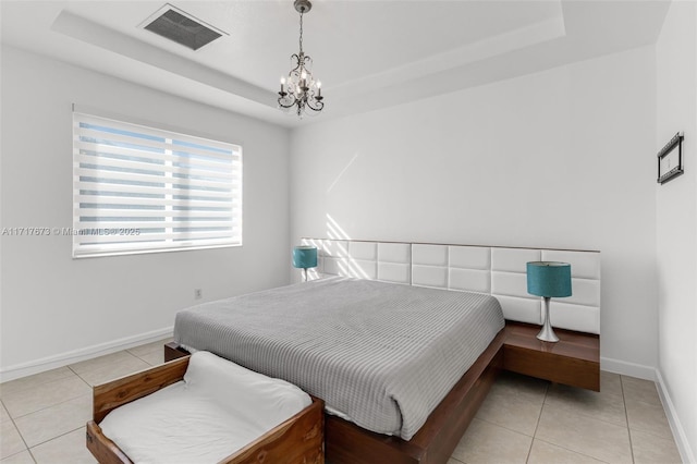 tiled bedroom featuring a tray ceiling and a notable chandelier