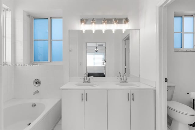 bathroom with vanity, a bathtub, and toilet