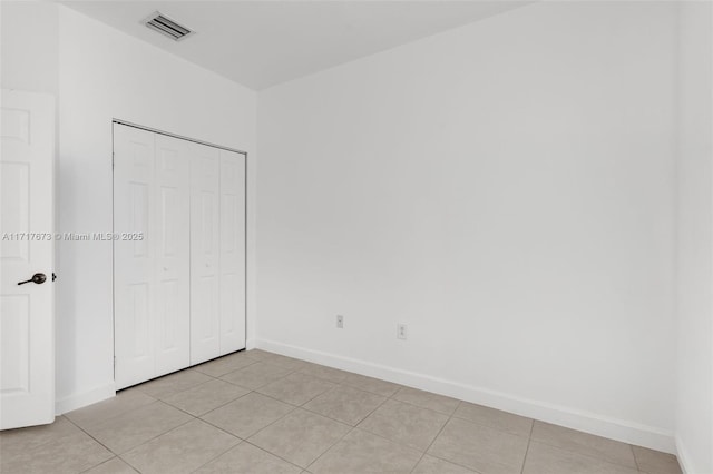 unfurnished bedroom with light tile patterned floors and a closet