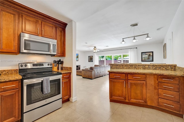 kitchen featuring light stone counters, pendant lighting, stainless steel appliances, and ceiling fan