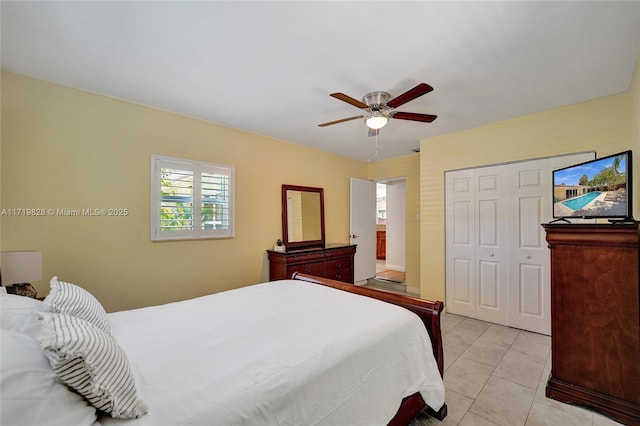 tiled bedroom with ceiling fan and a closet