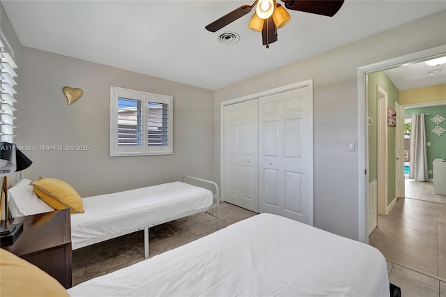 bedroom featuring light tile patterned floors, a closet, and ceiling fan