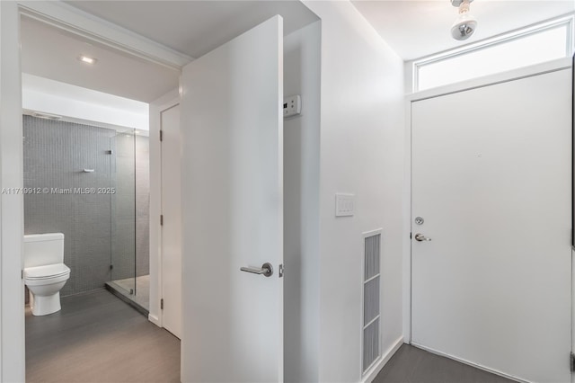 bathroom with a shower with door, hardwood / wood-style floors, and toilet