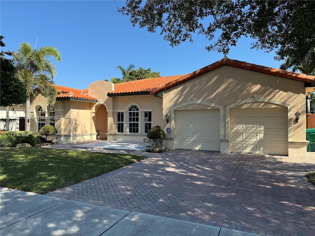 mediterranean / spanish-style home with a front yard and a garage