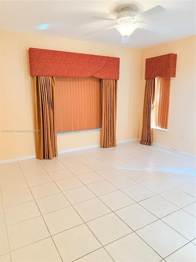 unfurnished room featuring light tile patterned floors and ceiling fan