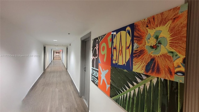 hallway with baseboards and wood finished floors