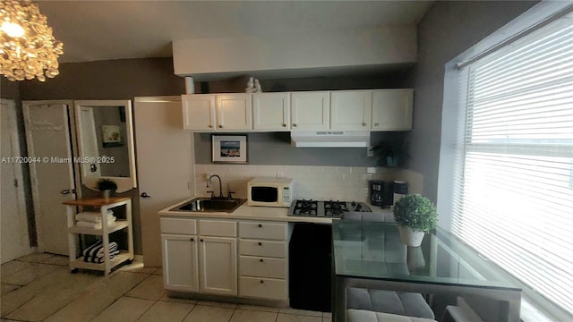 kitchen featuring backsplash, sink, white cabinets, and light tile patterned floors