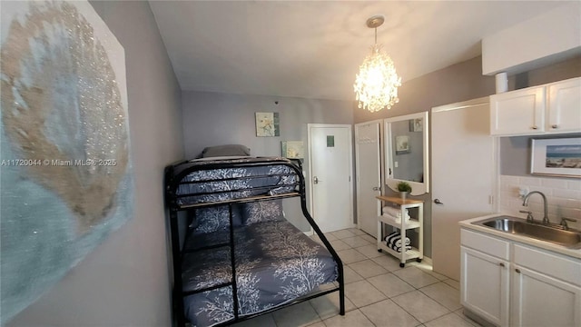 bedroom with a notable chandelier, light tile patterned floors, and sink