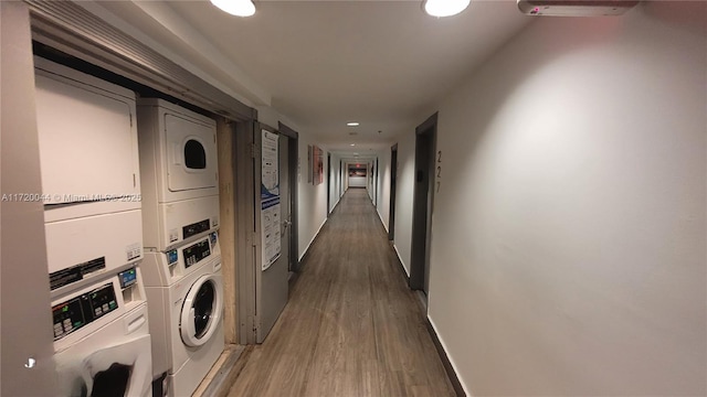 hall with recessed lighting, stacked washing maching and dryer, baseboards, and wood finished floors