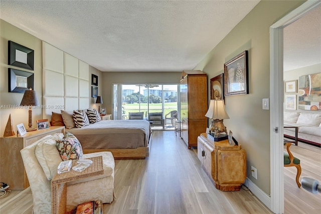 bedroom featuring light hardwood / wood-style floors and a textured ceiling