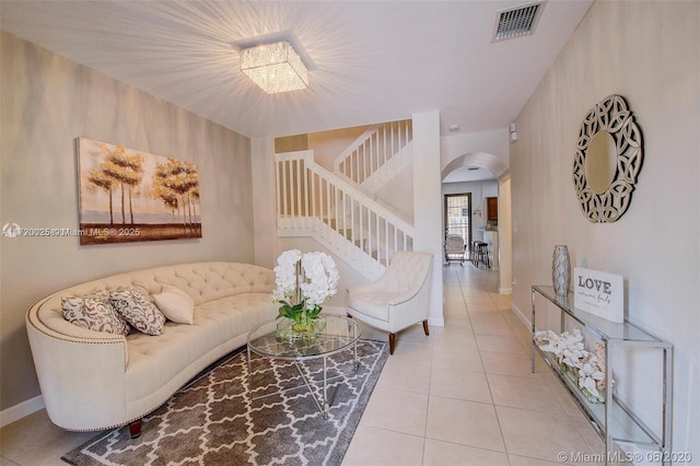 tiled living room with a notable chandelier