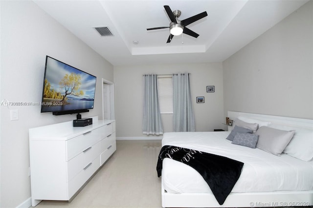 bedroom featuring a raised ceiling and ceiling fan