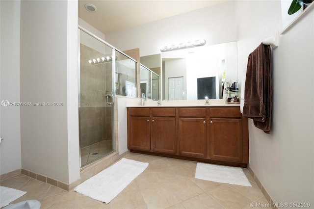 bathroom with tile patterned floors, a shower with door, and vanity