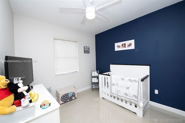 bedroom featuring ceiling fan and a nursery area