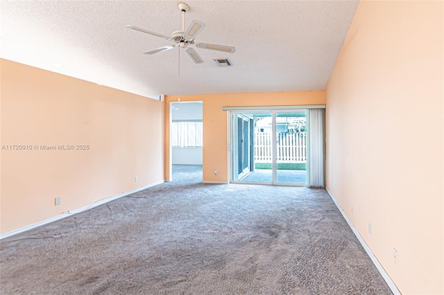 carpeted spare room featuring ceiling fan and a textured ceiling