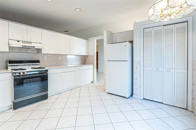 kitchen with white cabinets, decorative backsplash, white refrigerator, and range with gas stovetop