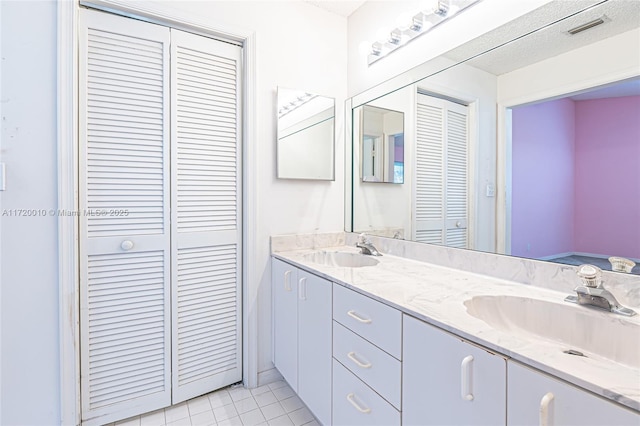 bathroom with tile patterned floors, vanity, and a textured ceiling