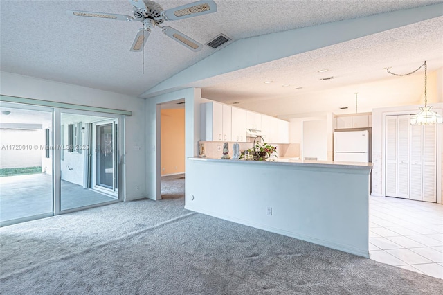 unfurnished living room with light carpet, a textured ceiling, and vaulted ceiling