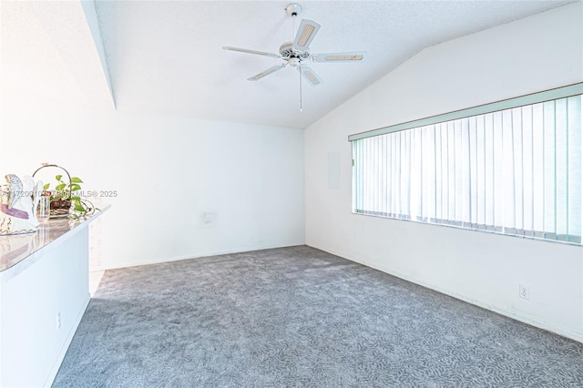 unfurnished room with carpet, a textured ceiling, vaulted ceiling, and ceiling fan