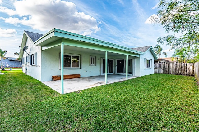 back of house featuring a patio area and a lawn