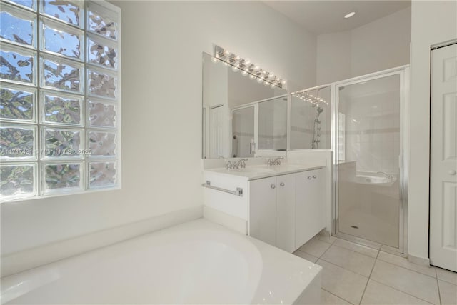 bathroom featuring tile patterned flooring, a garden tub, a shower stall, and vanity