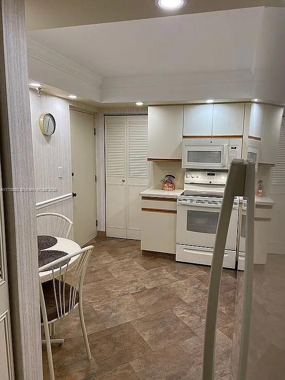 kitchen with white appliances and ornamental molding