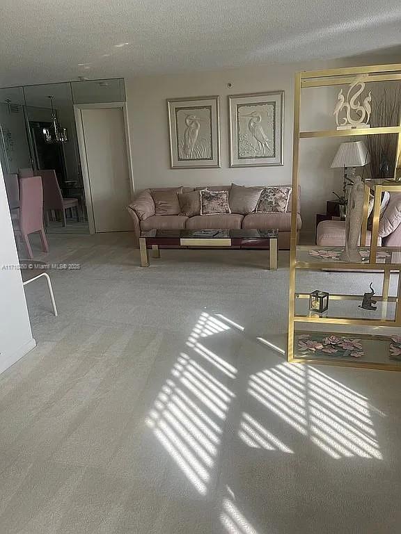 carpeted living room featuring a textured ceiling