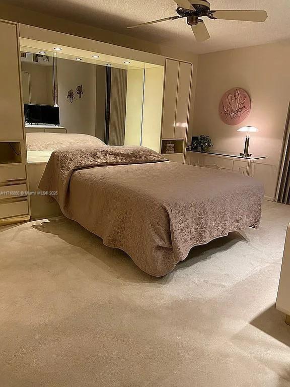 bedroom with carpet flooring, ceiling fan, and a textured ceiling