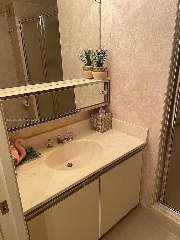 bathroom with tile patterned floors, vanity, and a shower with door