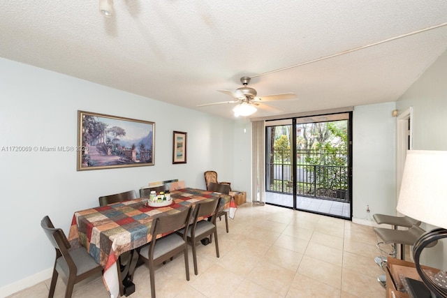 dining room with light tile patterned flooring, a textured ceiling, a wall of windows, and ceiling fan