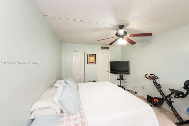 tiled bedroom featuring a textured ceiling, a closet, and ceiling fan