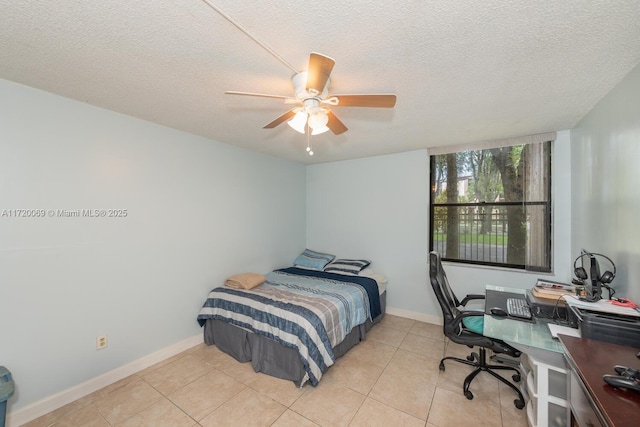 bedroom featuring ceiling fan, light tile patterned floors, and a textured ceiling