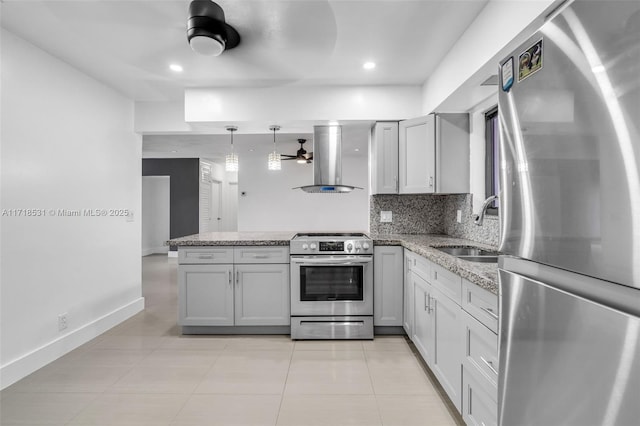 kitchen featuring light stone countertops, sink, wall chimney exhaust hood, decorative light fixtures, and appliances with stainless steel finishes