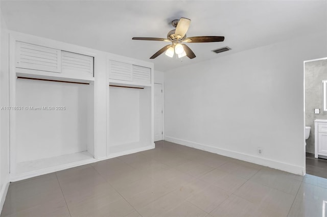 unfurnished bedroom featuring ensuite bath, ceiling fan, and a closet