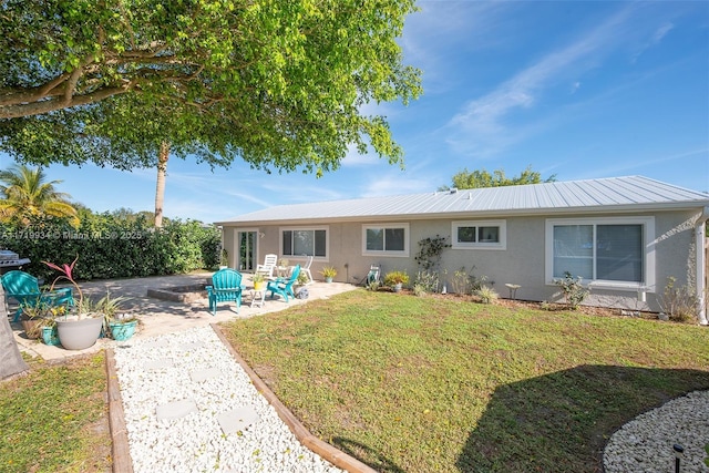 back of house featuring a patio area and a yard