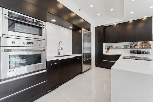 kitchen with sink, light tile patterned floors, dark brown cabinets, and appliances with stainless steel finishes