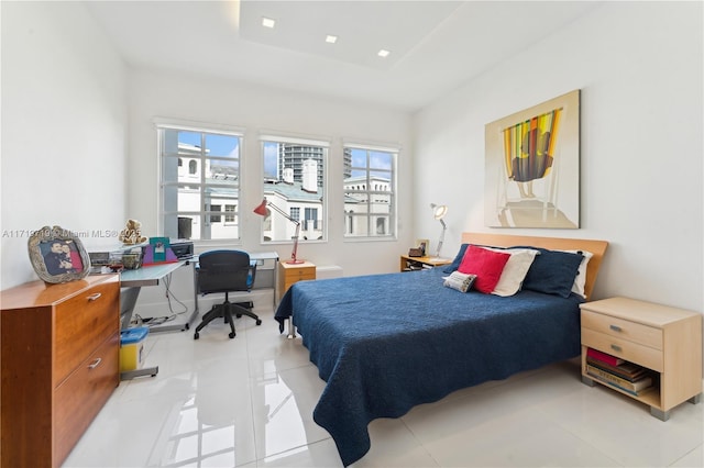 tiled bedroom featuring a tray ceiling