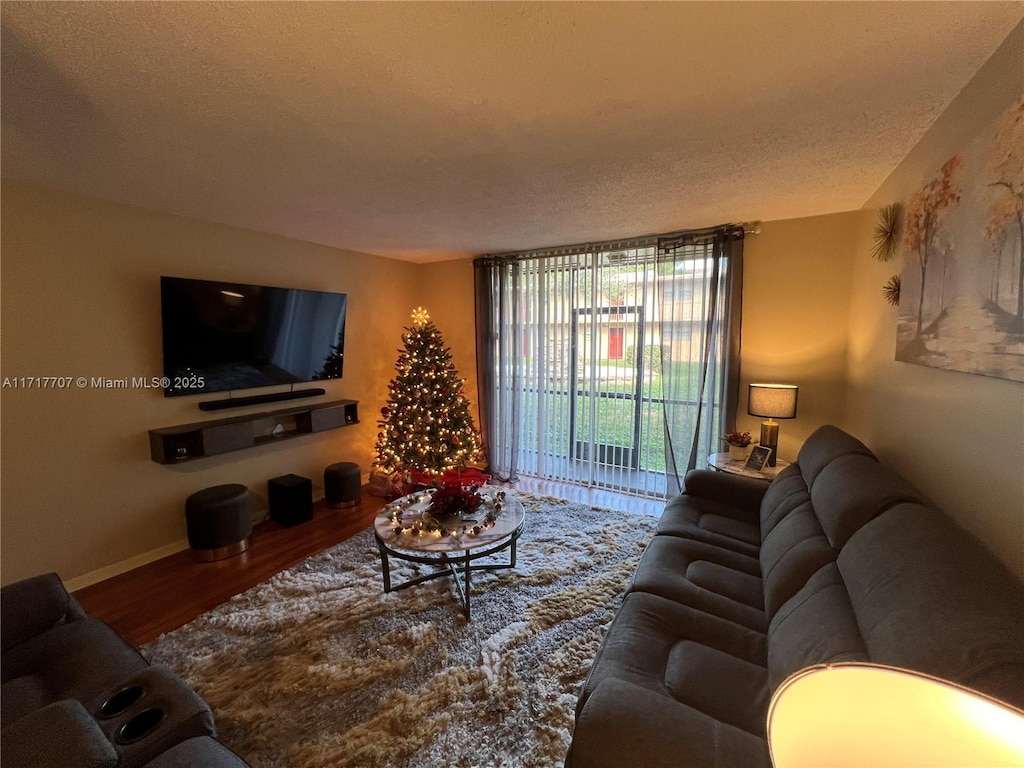 living room featuring wood-type flooring and a textured ceiling