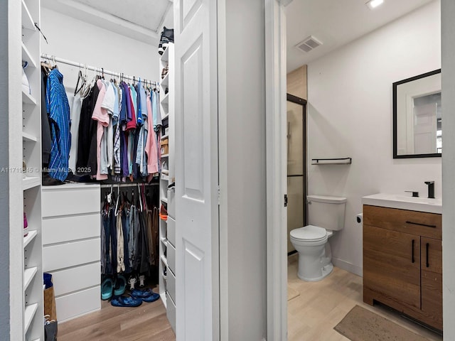 bathroom featuring hardwood / wood-style floors, vanity, toilet, and an enclosed shower