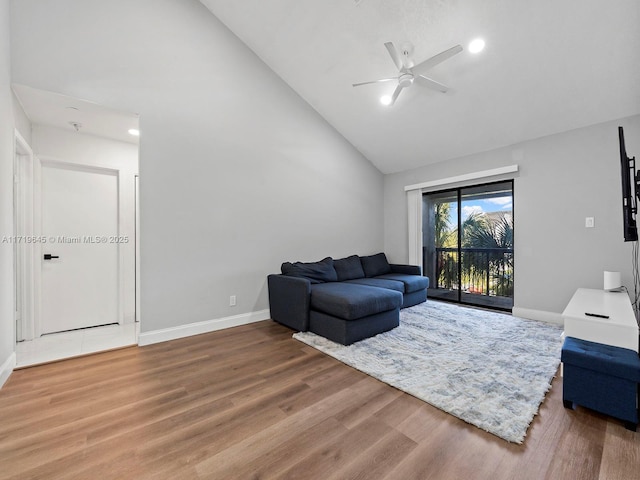 living room featuring hardwood / wood-style flooring, ceiling fan, and high vaulted ceiling