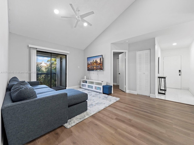 living room with wood-type flooring, high vaulted ceiling, and ceiling fan