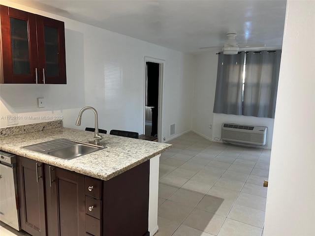 kitchen featuring light tile patterned floors, a wall unit AC, ceiling fan, dishwasher, and sink