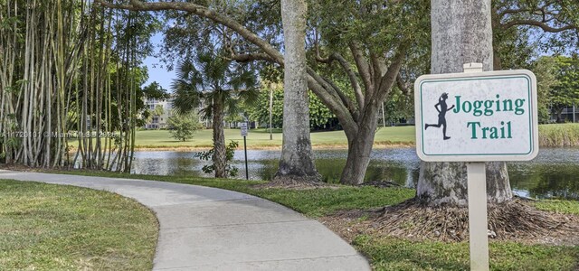 view of home's community featuring a lawn and a water view